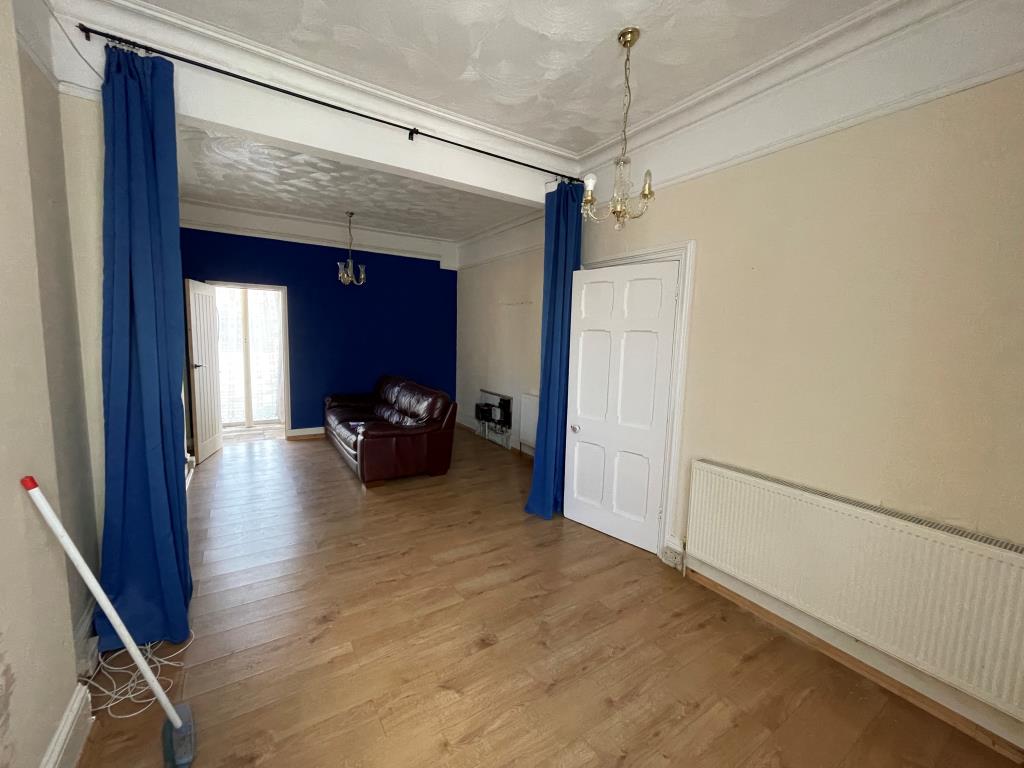 Lot: 144 - END-TERRACE PROPERTY ARRANGED AS THREE-BEDROOM HOUSE - Living room with access to shop front